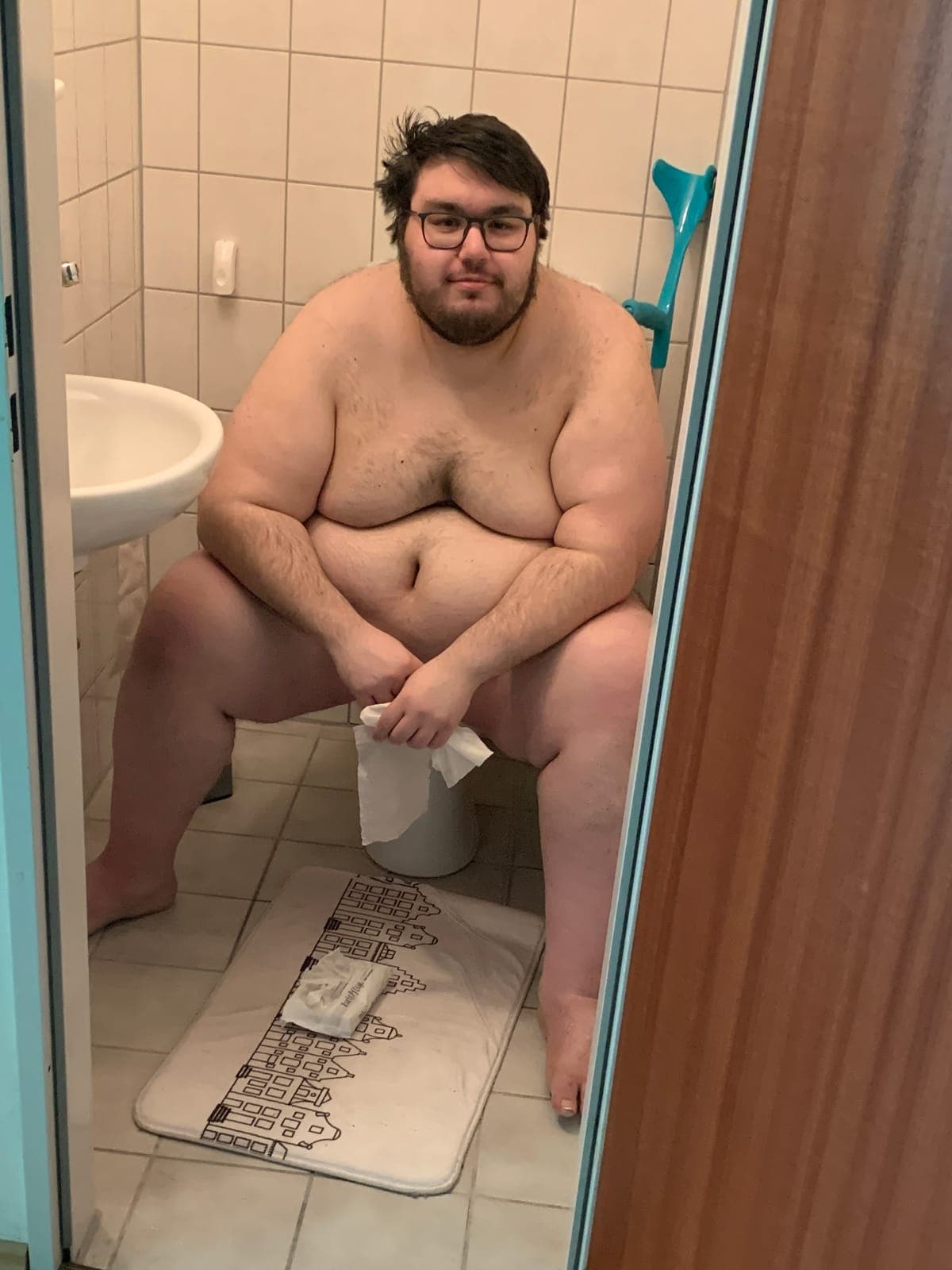 Dennis auf dem Höhepunkt seines Gewichts: sitzend im Badezimmer, oberkörperfrei, durch die offene Tür fotografiert
